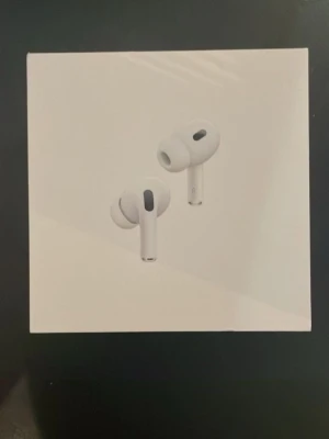 AirPods Pro 2nd Generation - Säljer ett par AirPods Pro 2nd Generation med MagSafe-laddningsetui. Produkten är i originalförpackning och ser ut att vara i nyskick. Aktiv brusreducering, transparensläge och hög ljudkvalitet. Perfekt för både musik och samtal. Ingen synlig skada eller slitage på förpackningen.