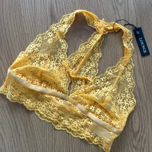 Ny Lounge Underwear Topp 💛 - Säljer en ny senapsgul topp från Lounge Underwear. Toppen är ärmlös och har vackra blommiga spetsdetaljer samt elastiskt band under bysten. Modell Floral Lace Triangle Bralette. Storlek S 💛