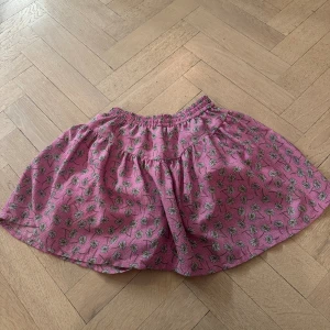 Rosa blommig kortkjol från Zara - Fin rosa kjol med maskrosor från Zara med inbyggda shorts. Jag säljer för 120kr, priset kan diskuteras.