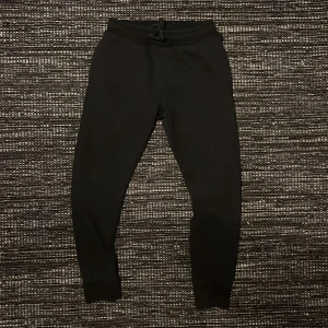 Svarta Träningsbyxor med snörning - Svarta mjukisbyxor med resår och snörning i midjan. Byxorna har smal passform med muddar vid bensluten och är tillverkade i mjukt bomullsmaterial. Perfekta för chill eller träning.Pris kan diskuteras