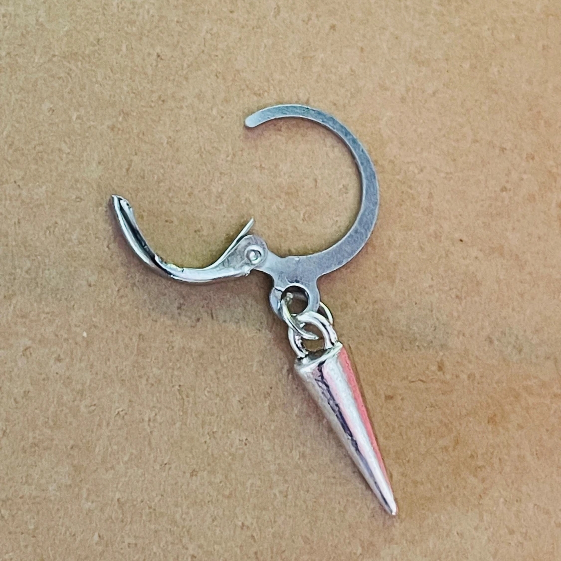 By prisförslag- 1 st Silvrigt örhänge med konformad hängande detalj