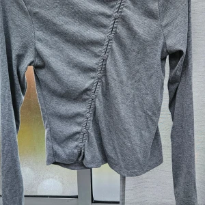 Grå ribbad långärmad tröja Amisu storl.Mer dom M står L - Säljer en grå långärmad tröja från Amisu i storlek L. Tröjan har ett ribbat tyg och coola diagonala knappar framtill som ger en unik look. Perfekt för dig som gillar stilrena detaljer och vill ha något som sticker ut lite i garderoben. Knappar är bara dekoration , liten I storl.mer M