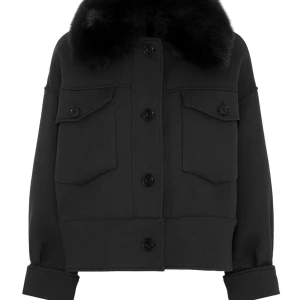 Meotine charlie jacket - Snygg svart kappa med fluffig pälsdetalj vid kragen och stora bröstfickor med knappar. Jackan har en boxig passform, långa ärmar och knäppning framtill. Perfekt för dig som gillar en cool och trendig look. den är ifrån meotine och modellen är charlie. kom privat för bilder