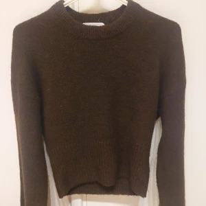 Mörkbrun stickad tröja Gina Tricot - Mysig mörkbrun stickad tröja från Gina Tricot. Tröjan är ganska figurnära med bred ribbad mudd nedtill och vid ärmslut. Endast använd ett par gånger.