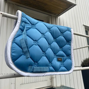 Equestrian Stockholm Schabrak - Beskrivning Nu säljer jag ett jättesnyggt, blått schabrak från Equestrian Stockholm. Det är i fint skick och är köpt förra året i februari.🌟 Det är i storlek ponny och har inga hårstrån på sig. Det är användt ett fåtal gånger.🦄 Tyvärr har de några fläckar på ena sidan som inte går bort med det vi har tvättat med, men jag tycker absolut inte det syns särskilt mycket på hästen, bara om man kollar på nära håll. Skylten där det står Equestrian Stockholm har också blivit rätt så repad. Nypris: ca 800