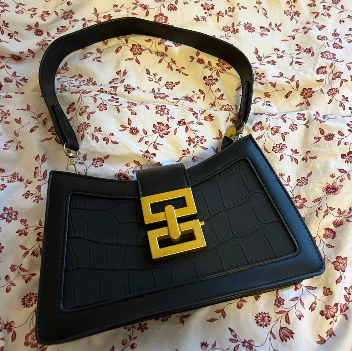 Svart axelväska med guldspänne