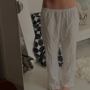 Vita linnebyxor från Gina Tricot - Säljer ett par vita linnebyxor från Gina Tricot i storlek S. Byxorna har rak passform, elastisk midja med snörning och är tillverkade i ett lätt och luftigt linnematerial. Perfekta för chill dagar och sommarhäng.