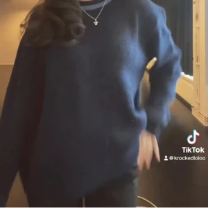 Mörkblå stickad tröja med öppen rygg - Säljer en mörkblå stickad tröja med loose passform och långärmade. Tröjan har en cool öppen rygg som ger en unik vibe och passar perfekt till svarta jeans. Enkel design utan mönster eller detaljer framtill, men ryggen gör hela looken speciell.