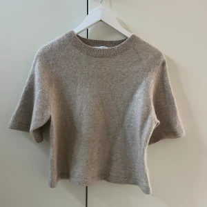 Beige stickad tröja & Other Stories - Biege stickad tröja från & Other Stories med korta ärmar och rund hals. Nypris 799kr💕