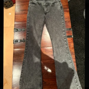 Bootcut svarta jeans med tvättad look - Snygga svarta lågmidjade jeans med tvättad finish och bootcut-ben som ger en schysst retrovibe. Passar någon som är på den kortare sidan💕