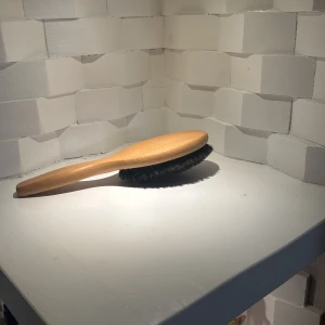 Träborste mjukt för håret - Detta är en borste med träskaft och mörka borst. Produkten ser ut att vara i gott skick utan synligt slitage eller defekter. Perfekt för daglig användning i hemmet. Ergonomiskt handtag för bekväm användning.