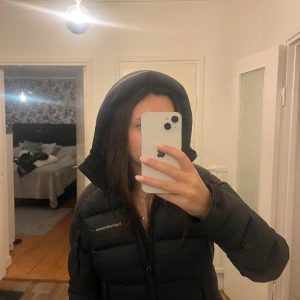 Svart Peak Performance dunjacka med huva - Säljer en svart dunjacka från Peak performance den är i jätte bra skick i storlek xs inga hål i den eller något skrov om ni har frågor (ordinarie pris 4500)