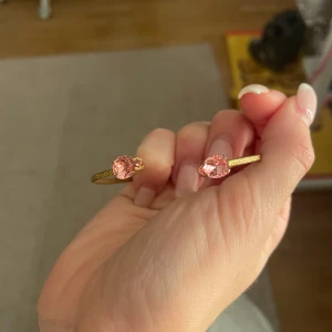 Guldfärgat armband med rosa stenar - Säljer mitt jättefina guldiga Caroline svedbom armband då den inte kommer till någon användning längre 