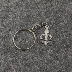 Lys Pendant Keyring - Stainless steel keyring with a delicate fleur-de-lis charm. Clean, sculptural, and modern.