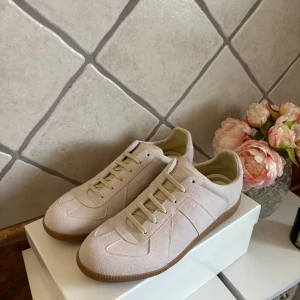 Maison Margiels sneakers beige mocka - Säljer ett par riktigt schysta Maison Margiela sneakers i ljusbeige mocka. Vill du va grischast i stan är detta ett par skor för dig helt oanvända. Går med på bud vid snabb affär!(Allt og ingår)