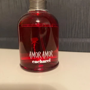 Amor Amor parfym av Cacharel - Använd, skulle säga testad. Mycket kvar då den inte passade mig.  AMOR AMOR EDP: EN NY INTENSIVITET AV FÖRSTA KÄRLEKEN Parfym Dam - Med Amor Amor Eau de Parfum introducerar Cacharel en ny intensitet av kärlek. En fängslande doft som varsamt dröjer sig kvar på din hud – hypnotisk och samtidigt djupt tröstande – som förkroppsligar spänningen av första kärleken. DOFTFAMILJ: Fruktig Blommig Parfym  DOFTNOTER: Toppnot: Röd ros Hjärtnot: Saftigt Päron Basnot: Vit Mysk