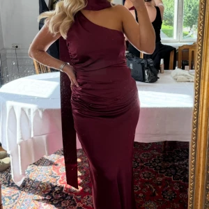 Vinröd långklänning från Six Stories - (På bild är strl 38. Säljer strl 40)  Aldrig använd och med samtliga lappar och förpackning kvar. Säljer då jag missade returneringsdatum och står med 2 likadana klänningar.   - Aldrig använd - Kvitto, lappar och förpackning kvar - Strl: 40, true to size  - Ordinarie pris: 1839 SEK (säljs fortfarande)  OBS - scarf ingår inte. Önskar man den och/eller strl 38 går det också att diskutera.