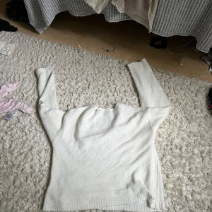 Vit v-ringad stickad tröja - Mysig vit stickad tröja  med v-ringning och långa ärmar. Tröjan har en enkel och stilren design, perfekt att matcha med jeans eller kjol. Den är mjuk och skön, och har en lätt loose passform.