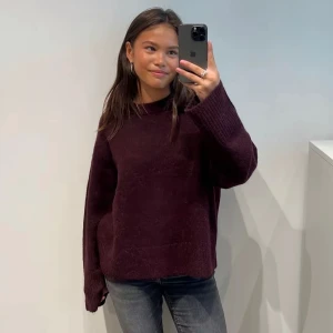 Oversized vinröd stickad tröja - Mysig oversized stickad tröja i vinrött med långa ärmar och breda muddar. Perfekt för kyliga dagar och enkel att styla med jeans eller kjol. Har endast använt 2-3 gånger. Den vineröda färgen är även en perfekt höstfärg