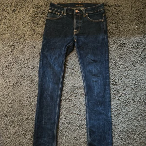 Nudie Jeans Grim Tim  - Riktigt feta Nudie jeans i modellen Grim Tim. Jeansen har en mörkblå färg och kommer med tiden få en ännu snyggare tvätt. Skicket är 8/10 eftersom att dem knappt är använda då dem är för små för mig. Storlek: W28 L30. Bara att skriva om ni har någon fråga!🙌