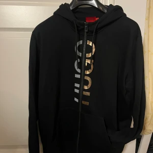 Svart hoodie från Hugo Boss - Svart hoodie från Hugo med dragkedja och huva. Bra skick, använd fåtalet gånger.