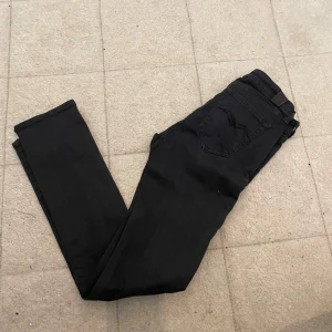 Svarta Replay Hyperflex jeans - Svarta Replay Hyperflex jeans med klassisk femficksdesign och diskret bakficka. Stretchigt material som ger en bekväm passform och följer kroppens rörelser. Perfekta för dig som gillar stilrena och smidiga jeans med modern känsla.