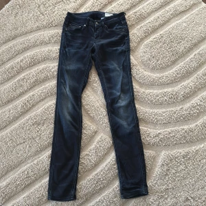 G-Star Raw 3301 skinny jeans blå - Snygga mörkblå jeans från G-Star Raw, modell 3301. De har klassisk femficksdesign, skinny fit och raka ben. Jeansen är tillverkade i ett stretchigt bomullsmaterial för en bekväm passform. Perfekta för dig som gillar en stilren och modern look.