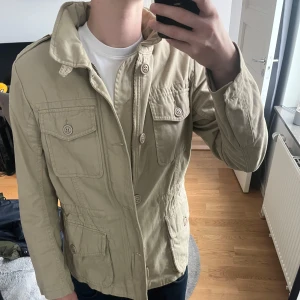 Field jacket  - Field jacket ifrån märket diesel, storlek S och passar mig som är 180 perfekt, materialet är som tyg, justerbar midja, innerfickor finns och en luva är uttagbar, skriv vid frågor!!
