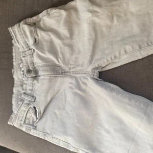 Ljusgrå jeans från D.M.D - Snygga ljusgrå jeans från D.M.D med klassisk femficksdesign och raka ben. Jeansen har bälteshällor, knapp och dragkedja framtill samt bakfickor med tydliga sömmar. Perfekta för dig som gillar en clean och stilren look.