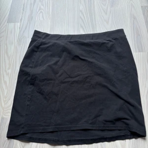 Svart kortkjol från H&M Divided - Enkel svart kortkjol från H&M Divided i basic stil. Kjolen har rak passform och är en tajt fin kjol, skick är svårt att säga då alla tycker olika men enligt mig är det ett bra skick på kjolen 