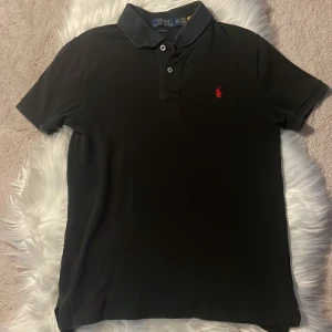 Svart Polo Ralph Lauren t-shirt - Svart piké från polo Ralph lauren. Slim fit modell och är perfekt för tillfällen man vill känna sig stilig! 