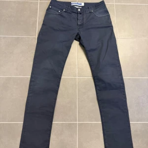 Mörkblå jeans från Jacob Cohen - Snygga mörkblå jeans från Jacob Cohen med klassisk femficksdesign och raka ben. Tillverkade i Italien av mjukt bomullsmaterial som ger en skön känsla. Perfekta för dig som gillar stilrena och tidlösa jeans.