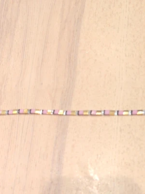 Färgglatt pärlarmband i pastell - Snyggt armband med små MIYUKI pärlor i pastellfärger som rosa, guld och svart. Armbandet har en tunn, rak design och stängs med en metallklämma. Perfekt för dig som gillar färg och vill ha något unikt på handleden. Låsen är även av rostfritt stål! 🩷