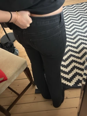 Svarta bootcut jeans med hög midja - Snygga svarta jeans med bootcut passform och hög midja. Jeansen har klassiska fem fickor och är tillverkade i ett mjukt jeansmaterial som sitter bekvämt. Perfekta för dig som vill ha en tidlös och stilren look. Använda 2 gånegwd!! Som nya