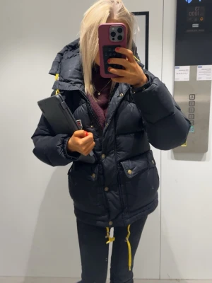 Svart pufferjacka från Fjällräven - hejssaaan! 💓 säljer min poppis jacka från fjällräven me gula detaljer och stor huva. Jackan har dragkedja, knappar och massor av fickor!  Perfekt för kalla dagar och riktigt snygg till vardagslooken🥰🥰 Storlek : Xxs      Nypris : 7899 köp för : 5500.                                    Skriv om ni har funderingar eller annat, tack på förhand!