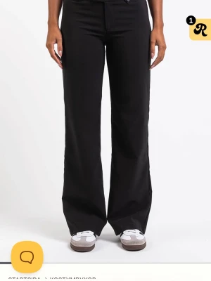 Svarta kostymbyxor - Snygga svarta kostymbyxor med hög midja och vid passform. Byxorna har klassisk design med raka ben och stängs med dragkedja och knapp framtill. Perfekta för en clean och stilren look. Helt nya och oanvända! regular i längd