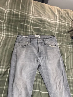 Grå jeans från Jack och Jones  - Säljer grå jeans skick 7/10 modell regular Clark storlek 29 30