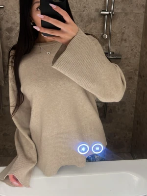 Beige stickad tröja - Säljer en beige stickad tröja med vida ärmar och ribbade muddar. Tröjan passar xs/s. Har ett litet hål på framsidan men inget man märker av.