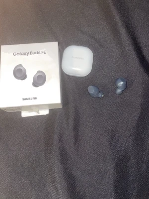 Samsung Galaxy Buds FE trådlösa in-ear - Samsung Galaxy Buds FE är trådlösa in-ear hörlurar i mörkgrå färg med matchande laddningsetui. Snygg och kompakt design, perfekt för musik och samtal på språng. Kompatibla med Android och har touchkontroller på sidorna. Levereras med originalförpackning.Inget fel på dom alls fick nya i present så vill sälja dom.