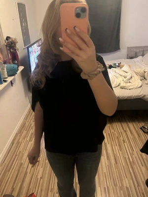 Svart oversized T-shirt / cape top - En svart oversized t-shirt/cape top med rund hals och korta ärmar. T-shirten har en loose passform och är perfekt för en avslappnad stil. Köpte den för-50 Säljer för 35. Sänker pris vid snabbaffär då ja vill bli av med den!!❣️❣️  ifrån lager 157.