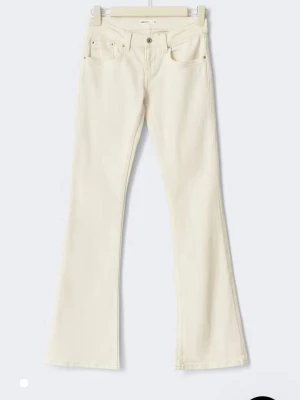 Vita bootcut jeans med detaljer - Snygga vita bootcut jeans från ginatricot med dekorativa sömmar  och små nitar på bakfickorna. Helt ny köpta och aldrig använda 