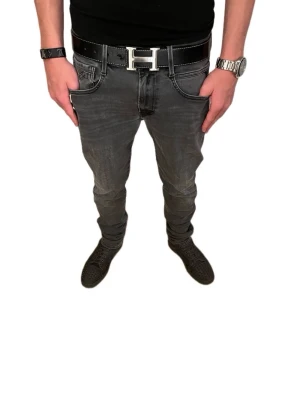 Replay Anbass Mörkgrå  - Snygga grå jeans från Replay med smal passform och klassisk femficksdesign. Jeansen har svarta sömmar och en diskret Replay-logga vid fickan. Perfekta för dig som gillar en modern och stilren look. Storlek W32 W34!