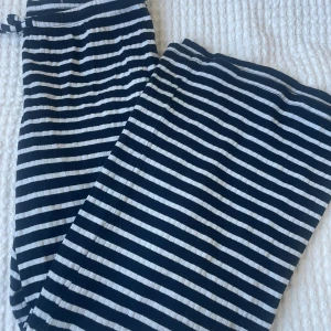 Randiga mjukisbyxor med snörning - Snygga mjukisbyxor med svarta och vita ränder. Byxorna har en bekväm resår i midjan och snörning för extra passform. Perfekta för chill dagar eller när du vill vara extra bekväm. Tillverkade i mjukt bomullstyg🖤