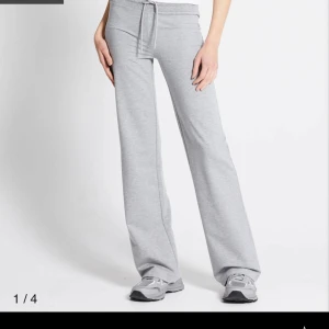 Grå mjukisbyxor med snörning - Superbekväma grå mjukisbyxor med breda ben och snörning i midjan. Perfekta för chill dagar eller när du vill ha en avslappnad look. Tillverkade i mjukt bomullsmaterial som känns skönt mot huden.