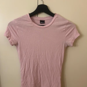 Ljusrosa t-shirt från Gina Tricot - En basic ljusrosa t-shirt från Gina. Har använt den ganska många gånger men skulle ändå säga att den är i bra skick