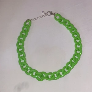 Grönt chunky kedjehalsband - Snyggt halsband med stora gröna länkar i plast och silverfärgat spänne. Kedjan har en modern chunky stil som verkligen sticker ut och ger en cool touch till din outfit. Perfekt för dig som gillar färg och statement-accessoarer.