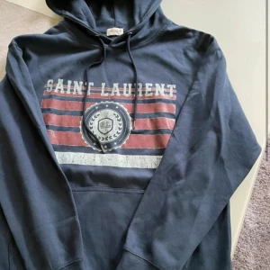Saint Laurent hoodie - En riktigt fet ysl hoodie som e helt ny i helt nytt skick använd 1 gång, skulle söga att den sitter mer som en m-l så alltså lite mindre i storleken. Priset är inte hugget i sten och tveka inte kring frågor🙌🙌