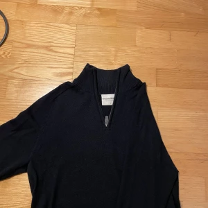 Svart stickad half zip från Bruun & Stengade - Mörkblå stickad tröja från Bruun & Stengade med ribbad krage och half zip-dragkedja. Långärmad modell i klassisk passform, perfekt till lager-på-lager. Enkel och stilren design som funkar till det mesta. Fin skick!
