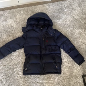 Mörkblå dunjacka från Polo Ralph Lauren - Säljer en mörkblå jacka från polo använd ett par gånger men fortfarande bra skick priset kan diskuteras.