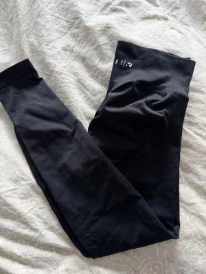 Svarta seamless leggings ICIW - Säljer ett par svarta seamless leggings från RELODE med hög midja och diskret logga framtill. De är tighta och stretchiga, perfekta för gymmet eller chill. Materialet är mjukt och följsamt syntet som sitter skönt hela dagen.